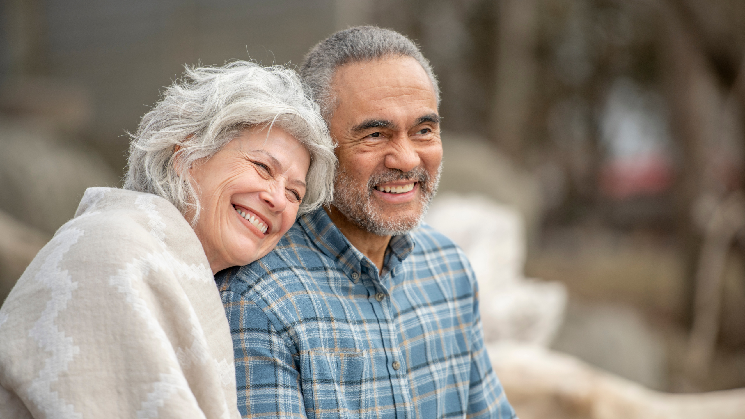 Smiling retired couple outdoors together in a relaxed setting